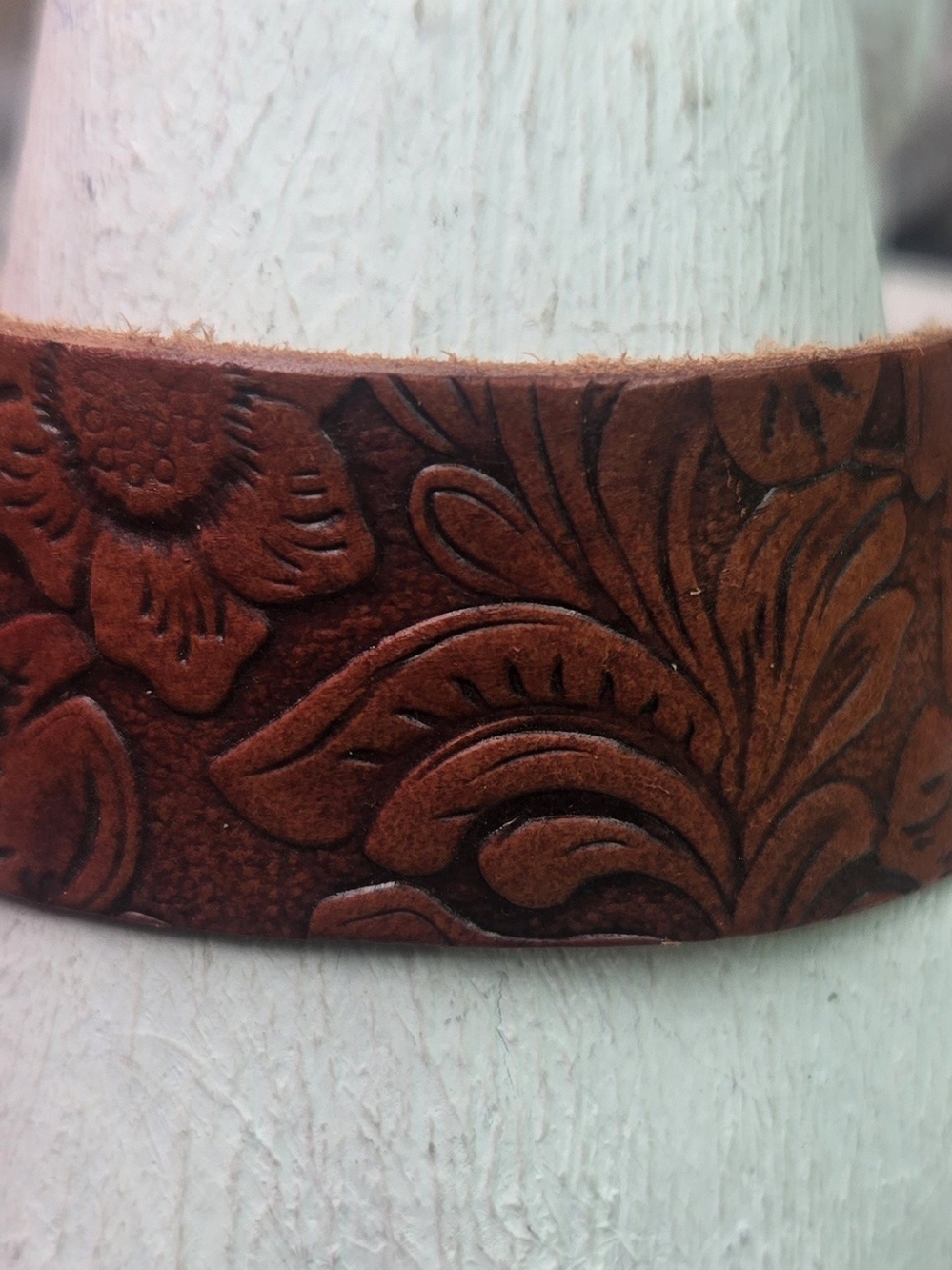 brown Western-style floral tooled leather snap bracelet. 